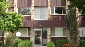 Front view of a multi-level residential building with large windows.