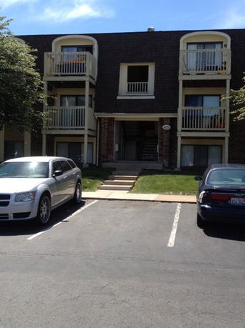 Front view of a multi-story apartment building with balconies.