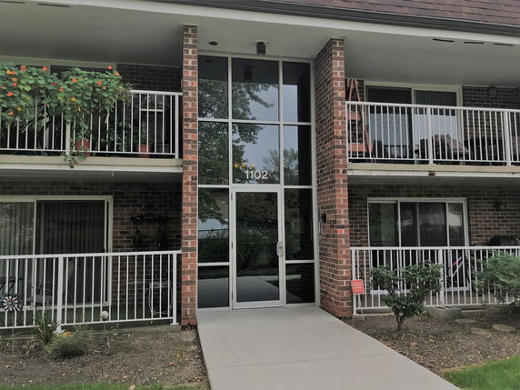 Front view of a multi-story brick building with balconies.