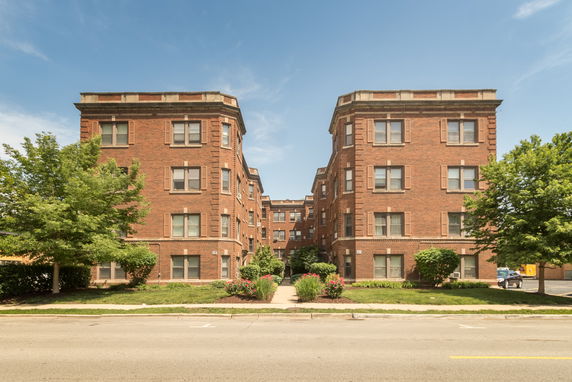 Front view of a multi-story brick apartment building.