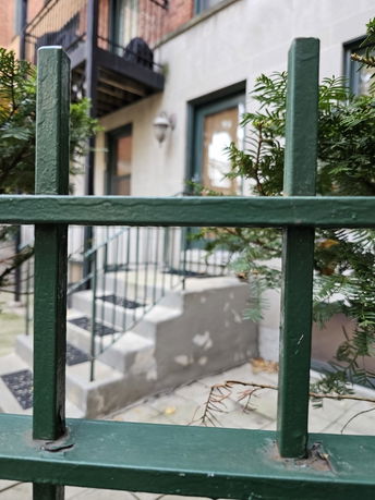Front view of a building entrance with stairs and railing.
