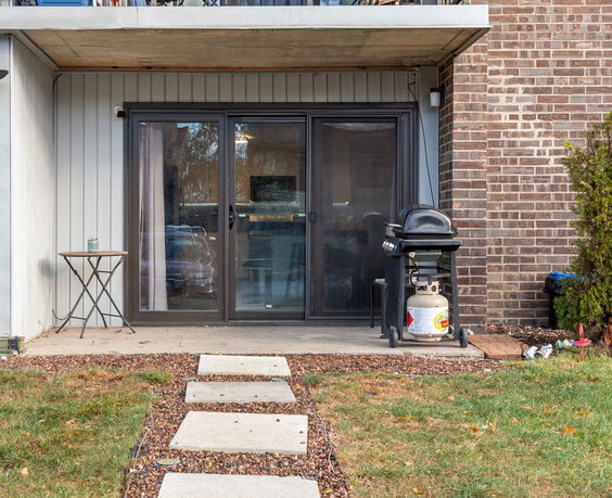 Front view of a building with sliding glass doors and a patio.