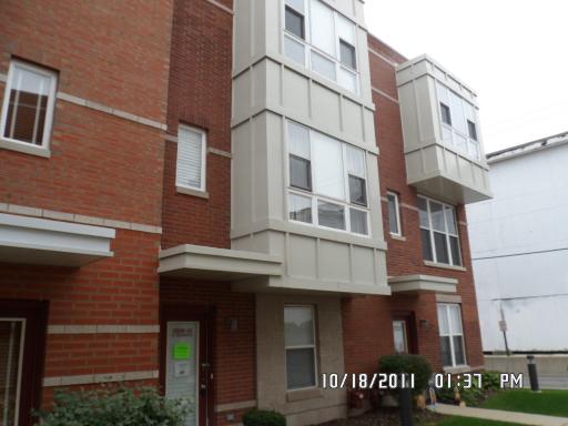 Front view of a multi-story building with brick and white paneling.