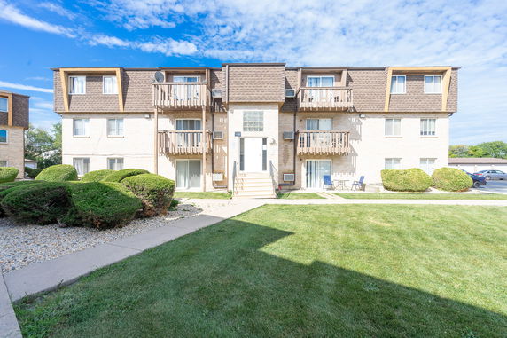 Front view of a multi-story residential building with balconies.
