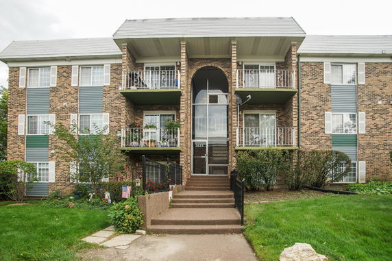 Front view of a three-story apartment building with balconies.