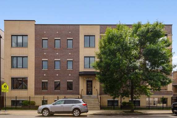 Front view of a three-story apartment building with a brick facade.