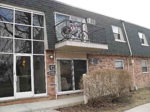 Front view of a two-story brick building with a small balcony.