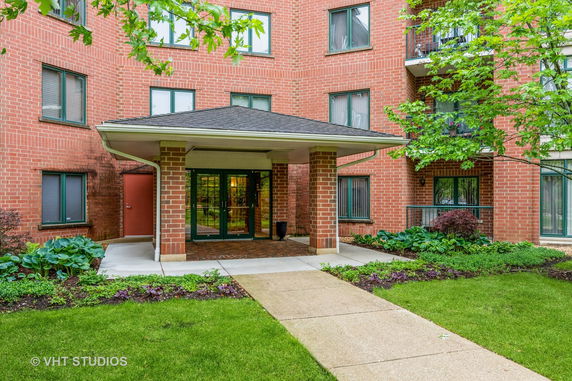 Front view of a brick residential building with an entrance canopy.
