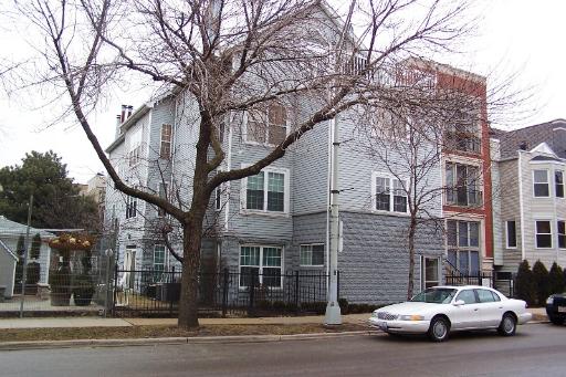 Front view of a multi-story residential building with a gray facade.