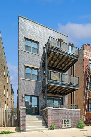 Front view of a multi-story brick building with balconies.