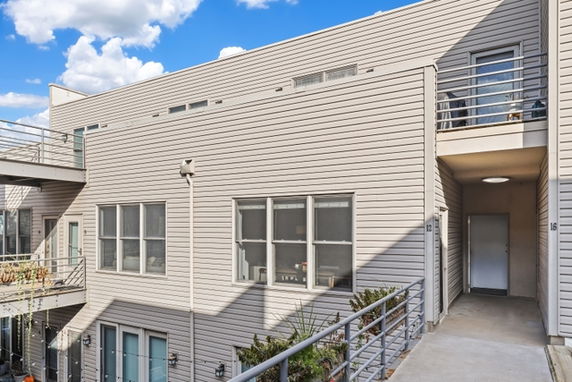 View of a modern building with multiple balconies and large windows.
