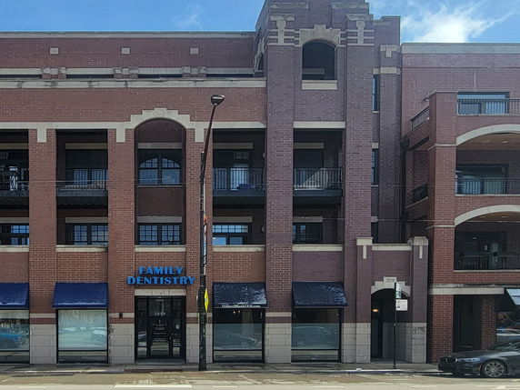 Front view of a multi-story commercial building with brick facade and dental office.