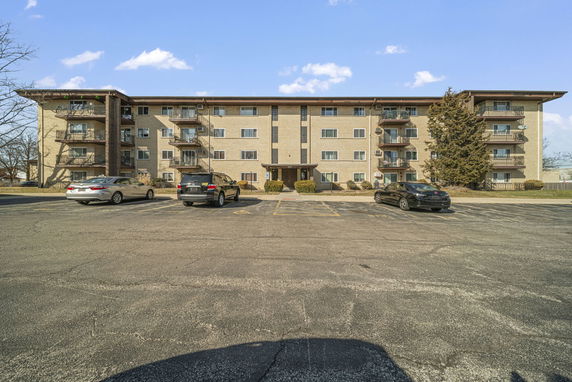 Front view of a four-story apartment building with balconies.