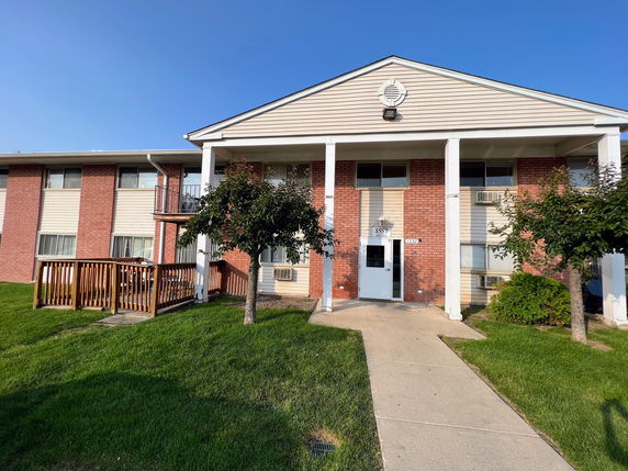 Front view of a two-story building with brick and siding exterior.