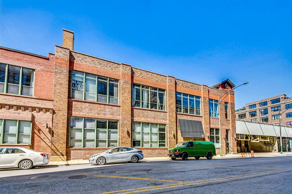 Front view of a two-story brick building with large windows.