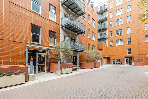 Front view of a multi-story building with balconies and brick exterior.