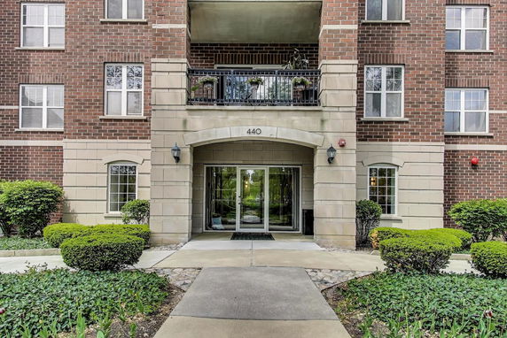 Front view of a multi-story brick apartment building with entrance.
