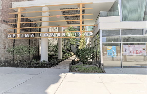 Front view of a building entrance with signage for Optima Towers 1580.