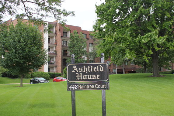 Front view of a multi-story brick building with balconies.