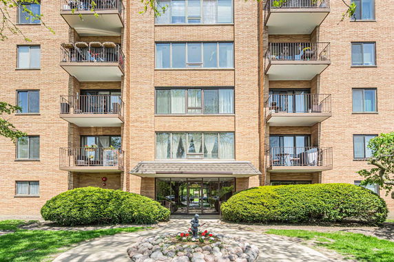 Front view of a multi-story apartment building with balconies.