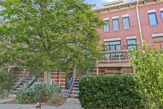 Front view of a multi-story brick building with stairs and balconies.