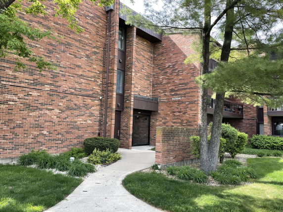 Front view of a multi-story brick apartment building.