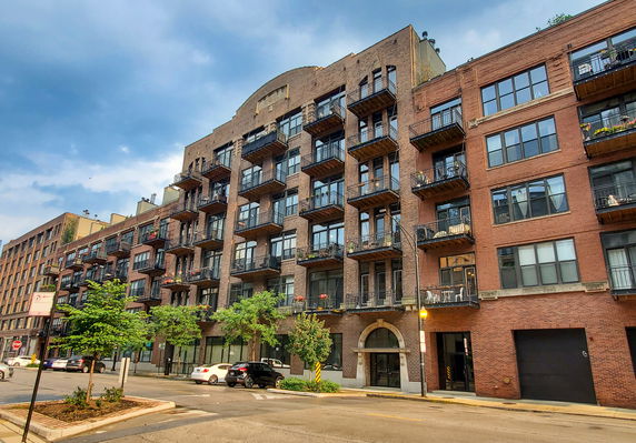 Front view of a multi-story apartment building with balconies.