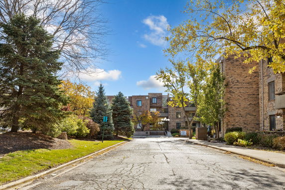 Front view of a multi-story brick building surrounded by trees.