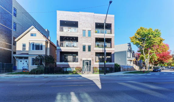 Front view of a multi-story building with balconies on each floor.