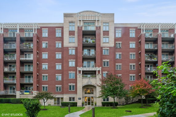 Front view of a multi-story apartment building with brick facade and balconies.