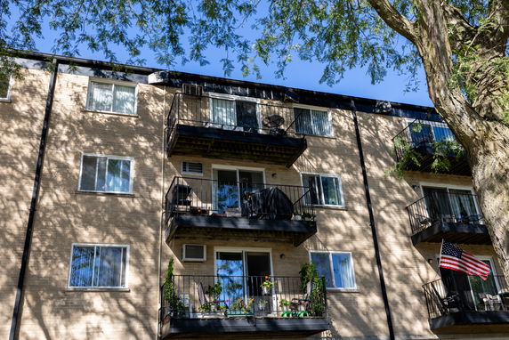 Front view of a multi-story apartment building with balconies.