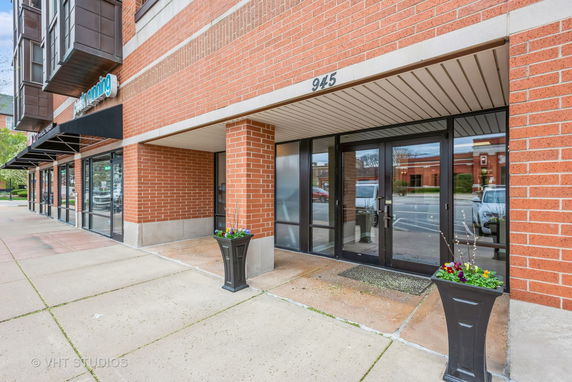 Front view of a brick building with large glass entrance doors.