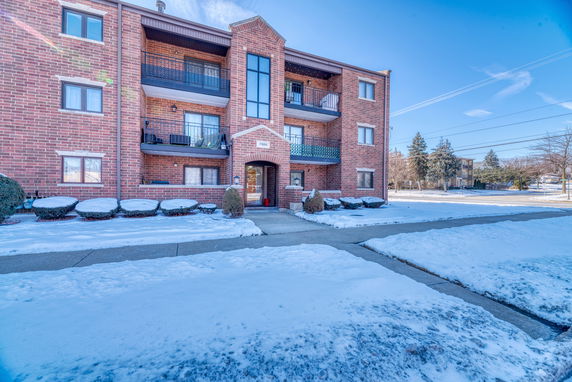 Front view of a multi-story brick building with balconies.