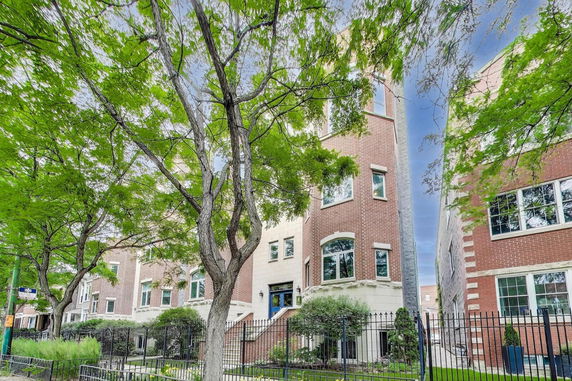 Front view of a multi-story brick building with large windows and a main entrance staircase.