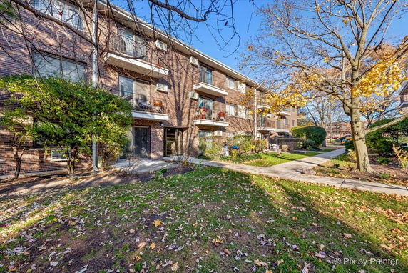Front view of a multi-story brick building with balconies.