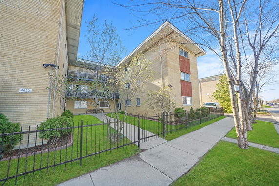 Front view of a multi-story apartment building with brick exterior.