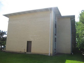 Side view of a three-story brick building with a flat roof.