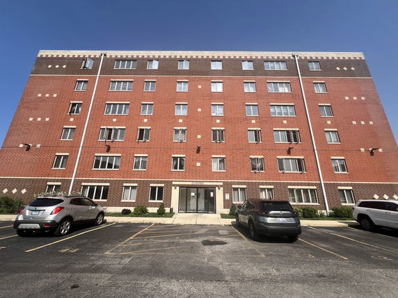 Front view of a multi-story brick apartment building.