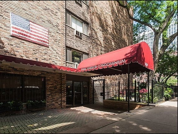 Front entrance of a condominium building with a red canopy.
