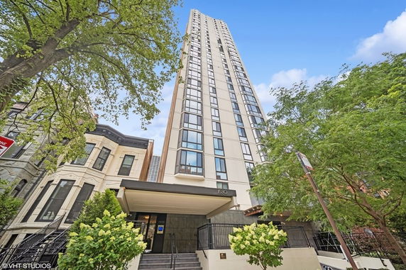 Front view of a high-rise residential building with multiple windows and a modern entrance.