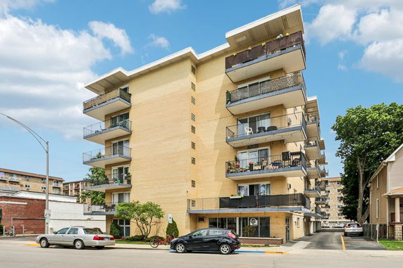 Front view of a multi-story apartment building with balconies.