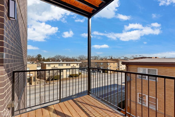 Balcony view of residential buildings and street in a suburban area.