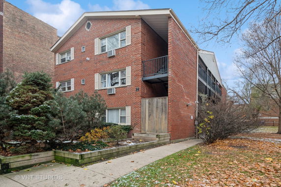 Front view of a multi-story brick building with balconies.