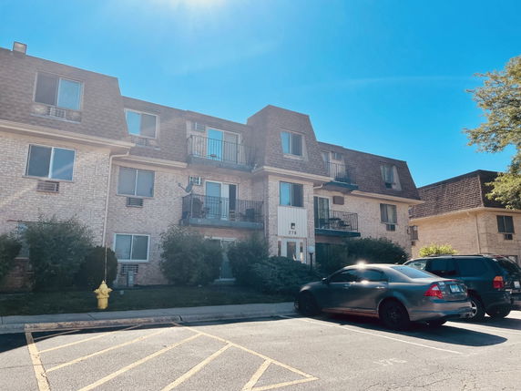 Front view of a three-story apartment building with balconies.
