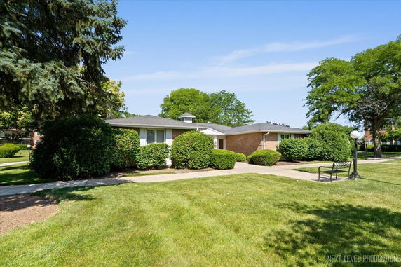Front view of a single-story brick house with a well-maintained garden.