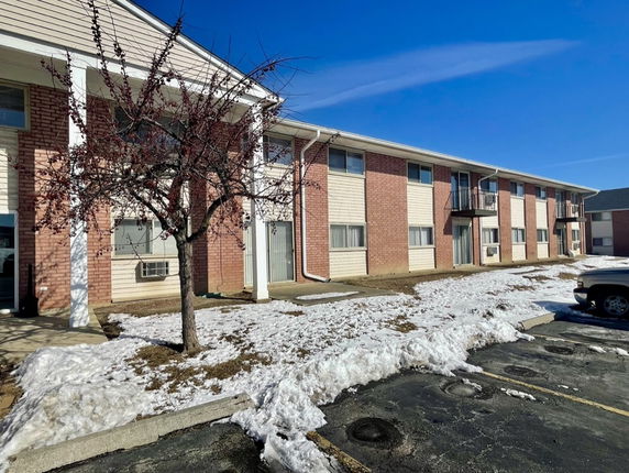 Front view of a two-story brick and siding residential building.