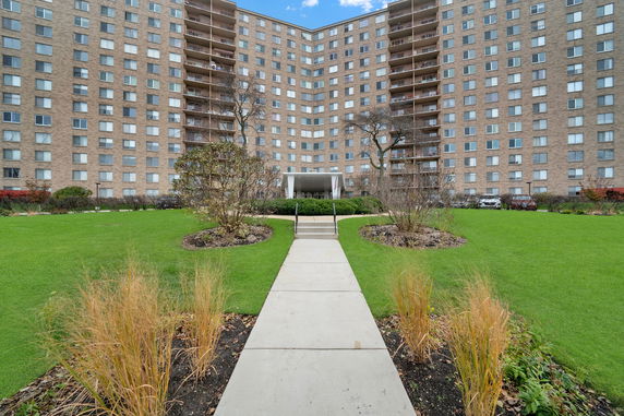 Front view of a large multi-story apartment building with numerous windows and balconies.