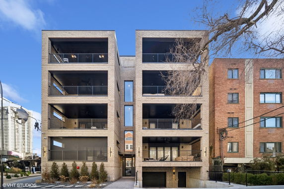 Front view of a modern multi-story building with balconies.