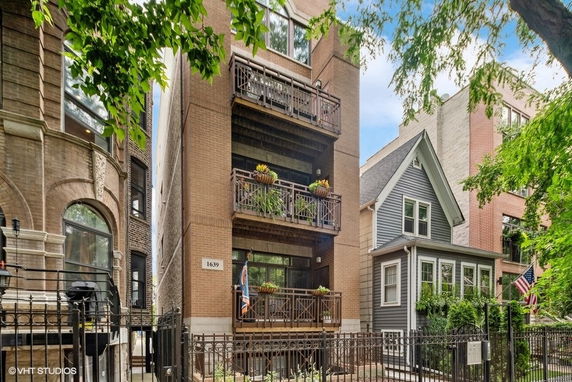 Front view of a multi-story building with balconies and brick facade