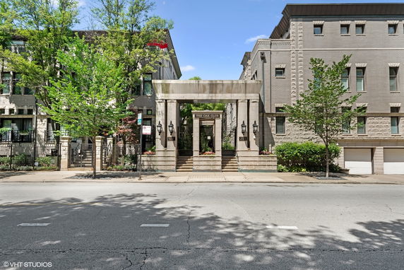 Front view of a multi-story building with a central entrance and decorative stone facade.